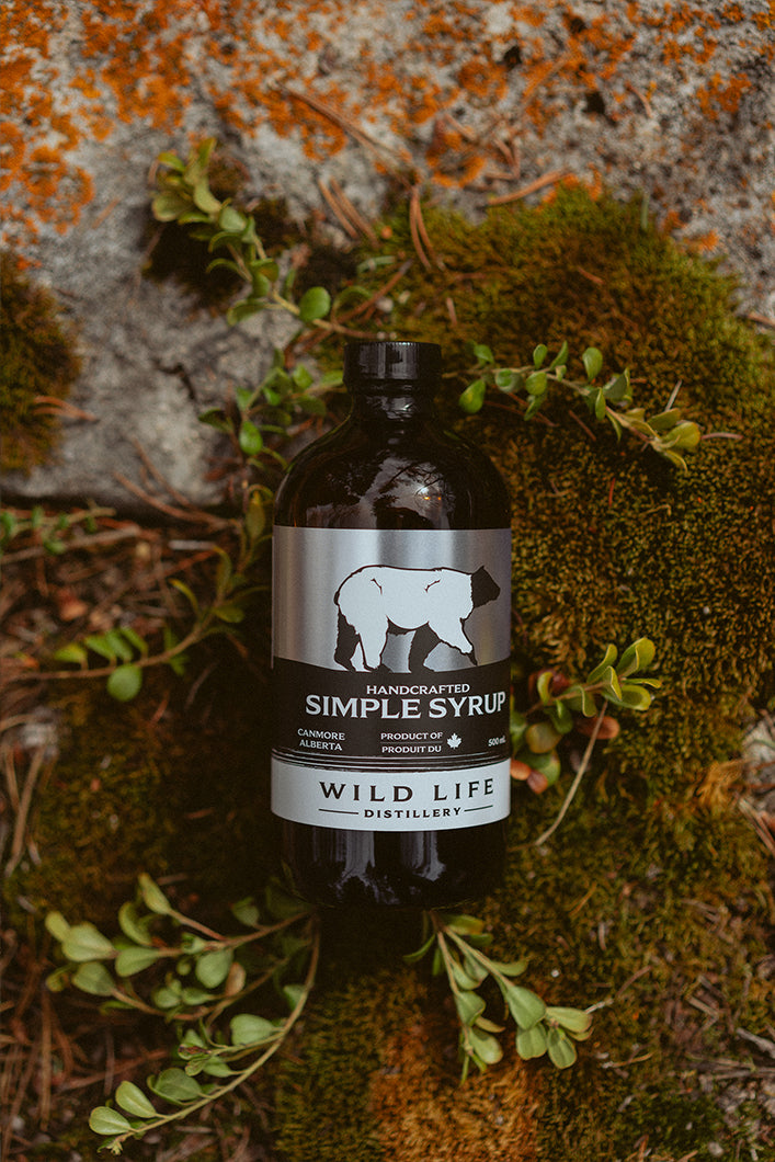 Wild Life Distillery Simple Syrup Bottle Displayed on a Rock